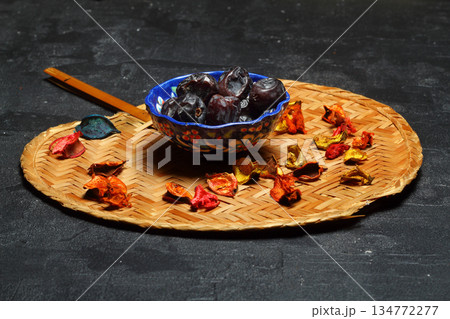 Dried dates on a wooden table in silver dishes close-up. Composition of dried dates in ramadan dish Dried dates on a wooden table in silver dishes close-up. Composition of dried dates in ramadan dish 134772277