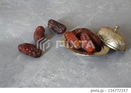 Dried dates on a wooden table in silver dishes close-up. Composition of dried dates in ramadan dish 134772357