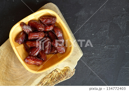 Dried dates on a wooden table in silver dishes close-up. Composition of dried dates in ramadan dish Dried dates on a wooden table in silver dishes close-up. Composition of dried dates in ramadan dish 134772403
