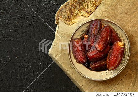 Dried dates on a wooden table in silver dishes close-up. Composition of dried dates in ramadan dish Dried dates on a wooden table in silver dishes close-up. Composition of dried dates in ramadan dish 134772407