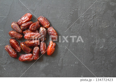 Dates on a black background. Dried fruits. Dried dates lie next to each other 134772423
