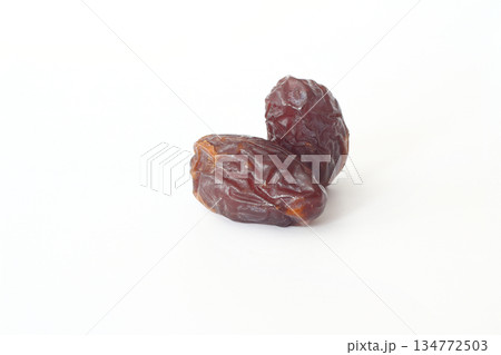 Dates on a white background. Dried fruits. Dried dates lie next to each other Dates on a white background. Dried fruits. Dried dates lie next to each other 134772503