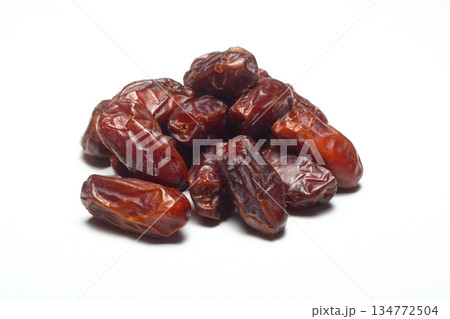 Dates on a white background. Dried fruits. Dried dates lie next to each other Dates on a white background. Dried fruits. Dried dates lie next to each other 134772504