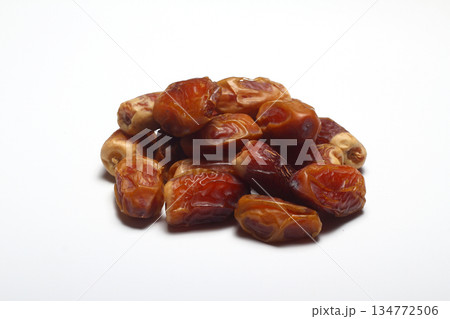 Dates on a white background. Dried fruits. Dried dates lie next to each other Dates on a white background. Dried fruits. Dried dates lie next to each other 134772506