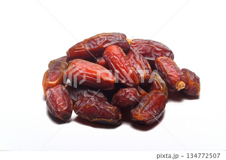 Dates on a white background. Dried fruits. Dried dates lie next to each other Dates on a white background. Dried fruits. Dried dates lie next to each other 134772507