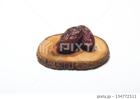 Dates on a white background. Dried fruits. Dried dates lie next to each other Dates on a white background. Dried fruits. Dried dates lie next to each other 134772511
