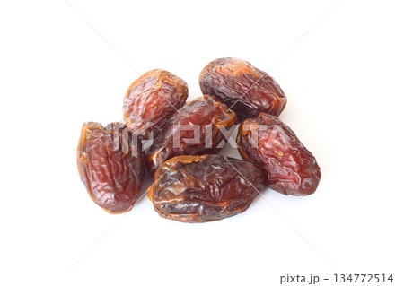 Dates on a white background. Dried fruits. Dried dates lie next to each other Dates on a white background. Dried fruits. Dried dates lie next to each other 134772514