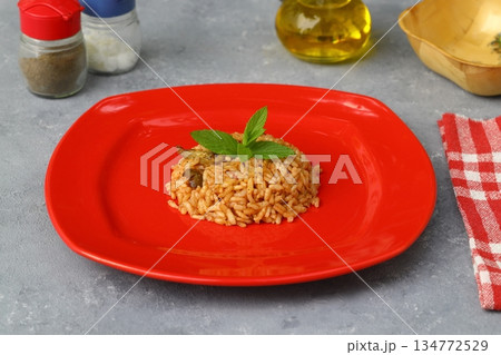 Turkish Stuffed Rice with Currants for Preparing Dolma in Plate with Spoon . Pilav or Pilaf 134772529
