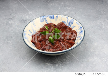 Cut raw beef liver with onions, spices, chili peppers and dill on wooden table, flat lay 134772589