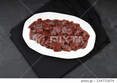 Cut raw beef liver with onions, spices, chili peppers and dill on wooden table, flat lay Cut raw beef liver with onions, spices, chili peppers and dill on wooden table, flat lay 134772674