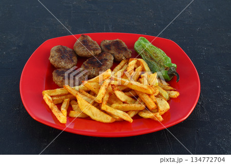 meatballs and potatoes on a red plate on black background meatballs and potatoes on a red plate on black background 134772704
