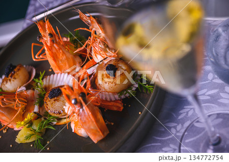 Dramatic low angle view of a tall coconut palm tree trunk reaching towards a blue sky with white clouds 134772754