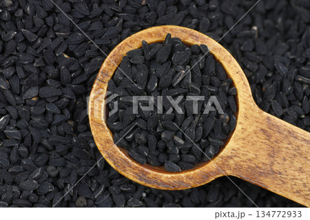 Black cumin seeds and essential oil with bowl and wooden shovel or spoon. Nigella Sativa in glass bottle. Organic herbal medicine for many diseases 134772933
