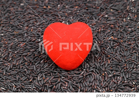 Riceberry rice grains, background and surface. Cross-bred rice variety from Thailand, with soft, deep purple whole grain rice grains, distinct from traditional black rice, a substitute for brown rice. Riceberry rice grains, background and surface. Cross-bred rice variety from Thailand, with soft, deep purple whole grain rice grains, distinct from traditional black rice, a substitute for brown rice. 134772939
