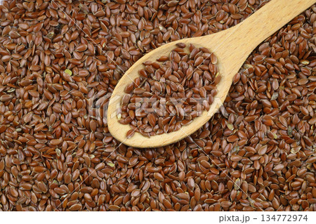 Flax seeds. Flaxseed powder in a wooden spoon. Standing on a Wooden background. 134772974