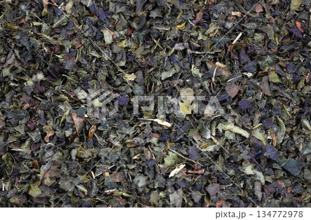 Tea green dry on wooden cutting board on dark concrete background Tea green dry on wooden cutting board on dark concrete background 134772978