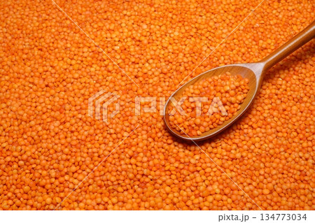 Red lentils scattered close-up with a spoon. 134773034