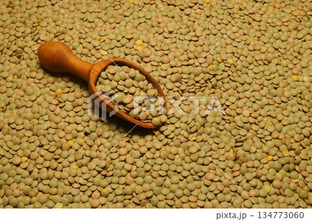 Green lentils scattered close-up with a scoop Green lentils scattered close-up with a scoop 134773060