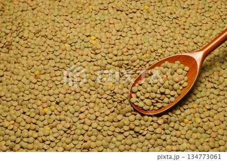 Green lentils scattered close-up with a spoon. Green lentils scattered close-up with a spoon. 134773061