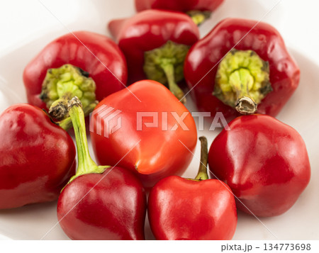 A plate of red peppers with one of them shaped like a heart A plate of red peppers with one of them shaped like a heart 134773698