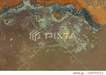 The image is of a rusty metal surface with a lot of holes and scratches The image is of a rusty metal surface with a lot of holes and scratches 134773712