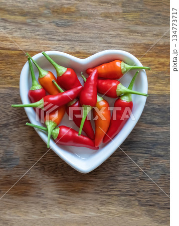 plate full of hot red peppers on wooden background with copy space 134773717