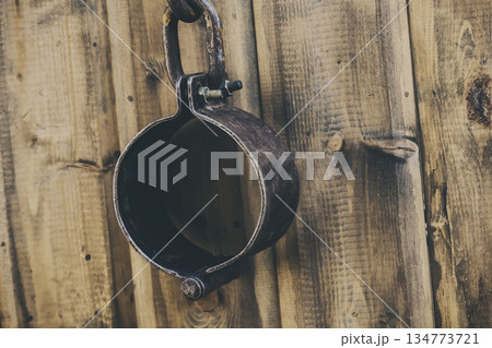 old and rusty shackles closed traditional design handcuffs hanging on a wall background 134773721