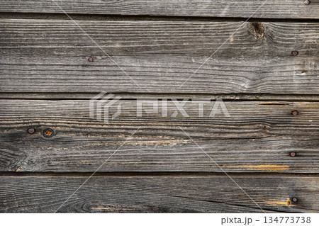 A wooden surface with a grainy texture and a few nails sticking out 134773738