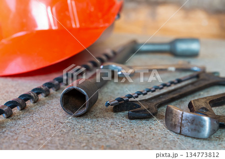The tools include a wrench, a screwdriver, and a drill bit. 134773812