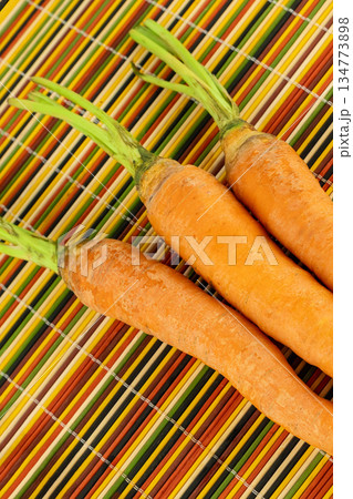 three red carrots lie on a bright colored background three red carrots lie on a bright colored background 134773898