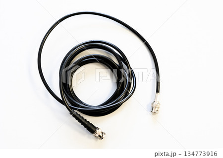 A black cable is laying on a white background 134773916