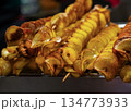 Delicious potato skewers topped with spices served at a street food market during evening hours 134773933