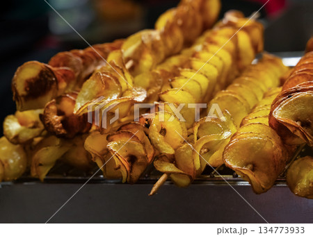 Delicious potato skewers topped with spices served at a street food market during evening hours 134773933