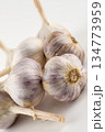 large and mature three heads of white garlic stand on a white background close-up 134773959