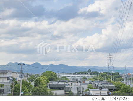 駐屯地と広がる雲、山を背景にした郊外の風景 134774289