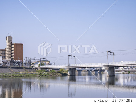 川面に映る橋と建物、穏やかな水鏡の景色 134774292
