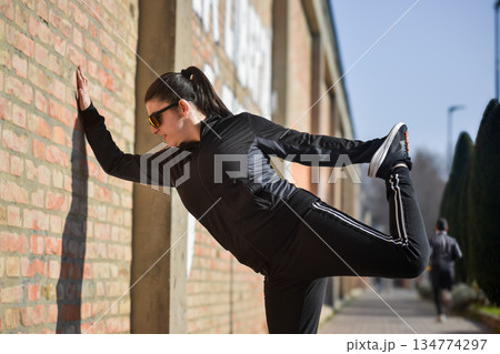 Woman with visual disabilities exercising in the park and stretching 134774297