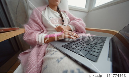 Young female engaging with multiple gadgets in moody pink lighting Young female engaging with multiple gadgets in moody pink lighting 134774568