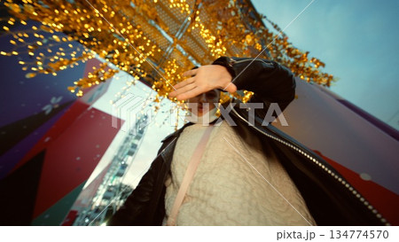 Dynamic urban fashion with confident model and shimmering skyline Dynamic urban fashion with confident model and shimmering skyline 134774570