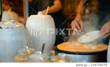 Warm market scene with fragrant steam and busy vendor at work 134774579