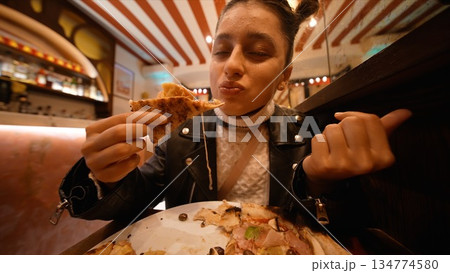 satisfied bite and gesture young woman approves pizza 134774580