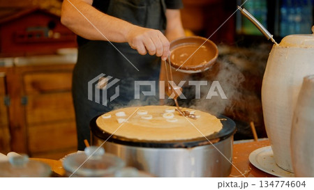 Sauce pouring art, Smoothly pouring savory sauce onto hot flatbread Sauce pouring art, Smoothly pouring savory sauce onto hot flatbread 134774604