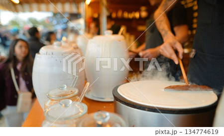vendor serves finished crepe on porcelain plate to customer 134774619