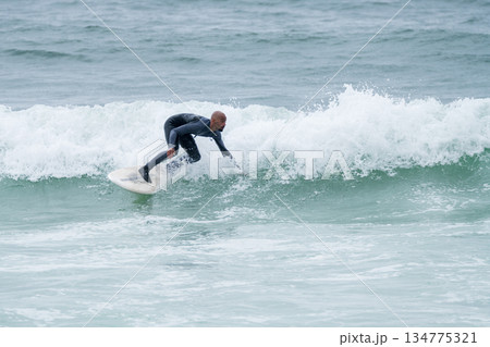 Surfer riding waves 134775321