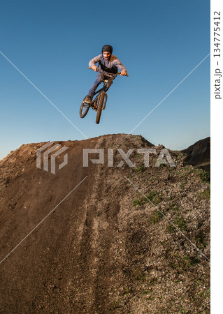 BMX Bike jump over a dirt trail 134775412