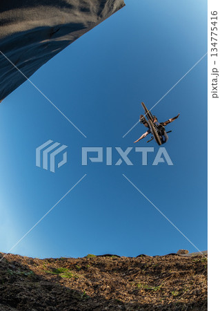 BMX Bike jump over a dirt trail BMX Bike jump over a dirt trail 134775416