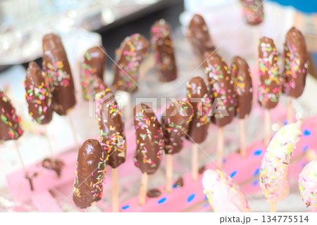 木板に並べたたくさんの手作りチョコバナナ 木板に並べたたくさんの手作りチョコバナナ 134775514