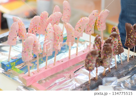 木板に並べたたくさんの手作りチョコバナナ 木板に並べたたくさんの手作りチョコバナナ 134775515