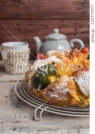 King Cake with nuts - Bolo Rei is a traditional Xmas cake with fruits raisins nut and icing on wooden table 134777077