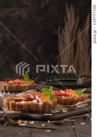 Nectarine vegan tarts with grated coconut and crunchy peanuts. Date, walnut, almond and hazelnut base. Nectarine vegan tarts with grated coconut and crunchy peanuts. Date, walnut, almond and hazelnut base. 134777100